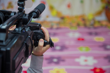 Hand control Video camera operator camcorder working with his equipment outdoor with blurred...