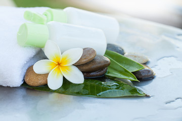 Two bottle on the white towel, flower and stones