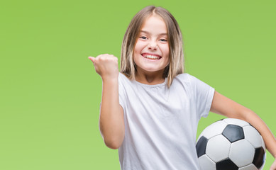 Young beautiful girl holding soccer football ball over isolated background screaming proud and celebrating victory and success very excited, cheering emotion © Krakenimages.com