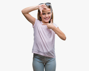 Obraz na płótnie Canvas Young beautiful girl wearing sunglasses over isolated background smiling making frame with hands and fingers with happy face. Creativity and photography concept.