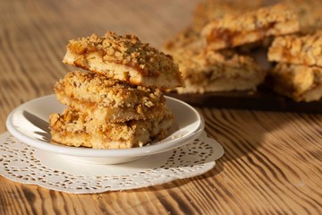 homemade apple pie on a white plate which stands on an old wooden table close-up with a copy space