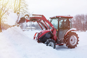 Obraz na płótnie Canvas Tractor cleaning snow in a park