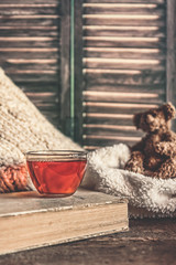still life book and a cup of tea in the living room on a wooden table, the concept of coziness and interior