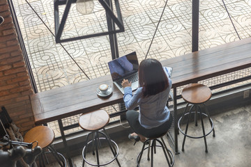 Fototapeta na wymiar Rear view photo of Asian woman working on laptop