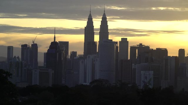 4k establishing cinematic shot of sunrise with silhouette Kuala Lumpur city skyline.