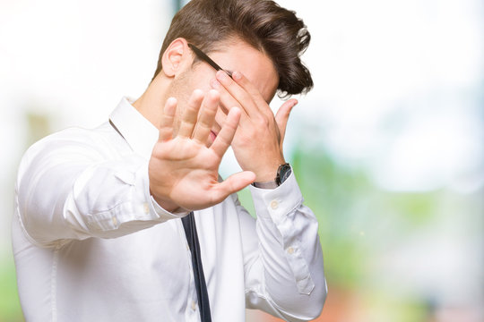 Young business man wearing glasses over isolated background covering eyes with hands and doing stop gesture with sad and fear expression. Embarrassed and negative concept.