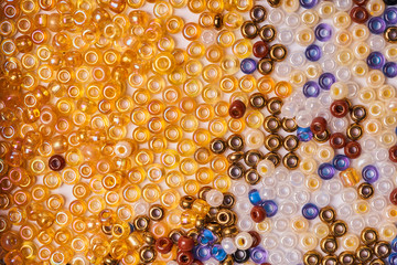 Multi-colored glass seed beads on a white background