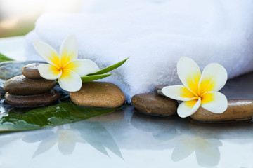 Fototapeta na wymiar Spa flowers and stones with towel for massage treatment