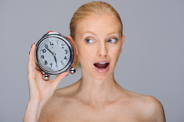 Woman with alarmclock in the hand