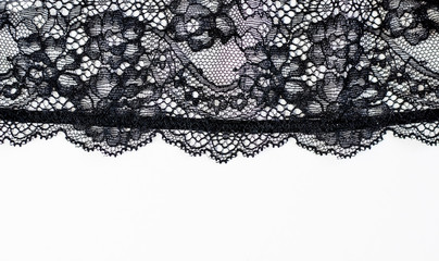 Black lace texture with flowers on a white background.Background of black lace with a flower pattern on a white background. Black guipure. Black fabric with an ornament.  - obrazy, fototapety, plakaty