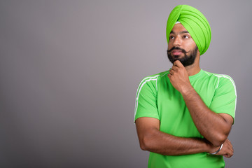 Young handsome Indian Sikh man wearing turban and green shirt