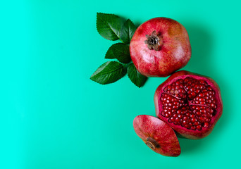 Pomegranate red fruit on green background, top view