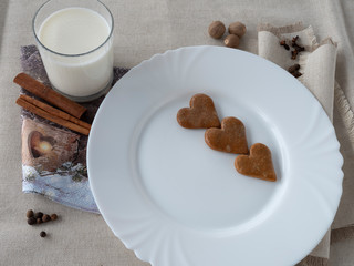 The glass of the milk with handmade cakes on the plate and with  serviettes with  allspices on the natural tablecloth This picture have made by middleformat camera