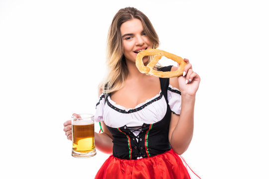 Portrait of a gorgeous sexy Bavarian girl sipping delicious beer from a mug, holding pretzel, isolated on white. Cheerful Okoberfest or St. Patriks waitress drinking beer, copy space