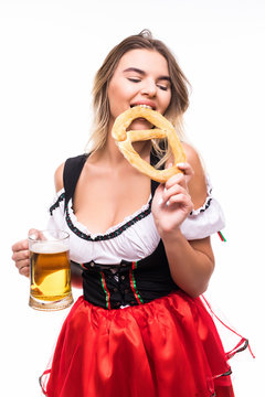 Portrait of a gorgeous sexy Bavarian girl sipping delicious beer from a mug, holding pretzel, isolated on white. Cheerful Okoberfest or St. Patriks waitress drinking beer, copy space