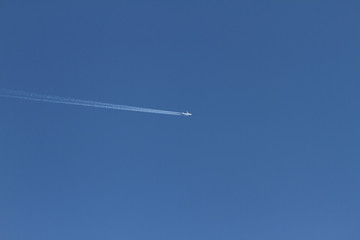 Airplane on a blue sky. Dream vacation concept. travel and tourism. Blue background texture. Wallpaper of airplane in the sky.
