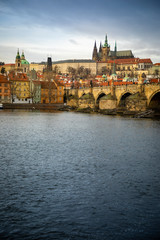 Obraz premium Panorama of Charles bridge and Prague castle over Vltava river in cloudy day, Czech Republic