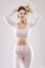 Fototapeta premium Portrait of a pretty young female wearing pink costume, against white background