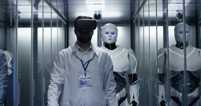 Medium shot of an engineer testing on robot controls using vr headset
