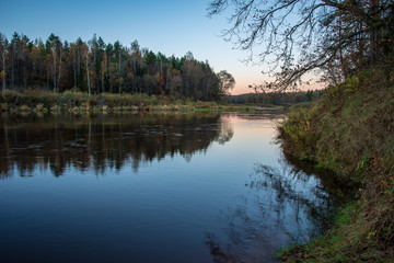 Fototapeta na wymiar blue sky and clouds reflecting in calm water of river Gauja in latvia in autumn