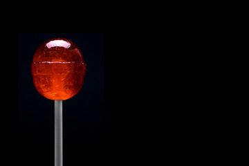 Caramel candies and lollipops. Colored candies. On a black background. free copying space.