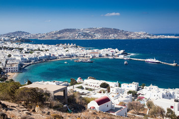 panoramic view of the Mykonos town harbor with famous windmills from the above hills on a sunny...