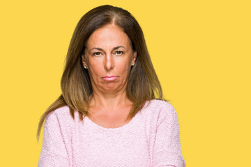 Beautiful middle age adult woman wearing winter sweater over isolated background skeptic and nervous, disapproving expression on face with crossed arms. Negative person.
