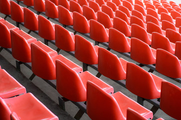 Naklejka premium Red seats in the stadium. Empty seat of football stadium