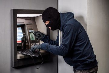 Hacker stealing password and identity on atm machine. Computer crime concept.