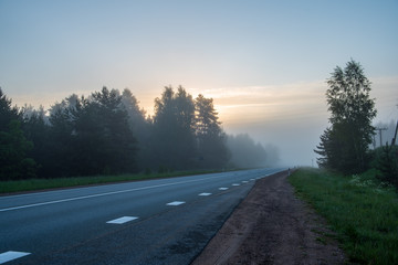 Fototapeta premium empty asphalt road with white lines painted in misty morning