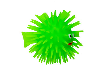Rubber toys. Funny green puffer fish made of rubber. Cute toy fish isolated on a white background. Macro.
