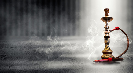 Hookah smoking on a concrete background, illuminated by the spotlight, neon light, smoke