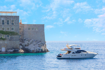 Part of the island of Sveti Stefan and sailing out of the Bay yacht, removed from the opposite shore