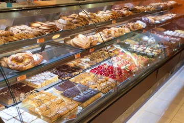 Keuken spatwand met foto Verschillende soorten heerlijke taarten in de vitrine van de banketbakkerij. © herraez