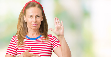 Beautiful middle age woman wearing casual stripes t-shirt over isolated background Swearing with...