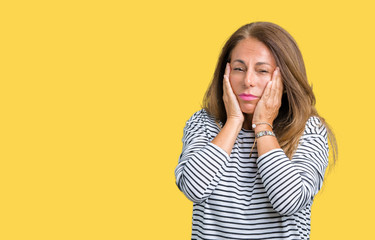 Beautiful middle age woman wearing stripes sweater over isolated background Tired hands covering face, depression and sadness, upset and irritated for problem