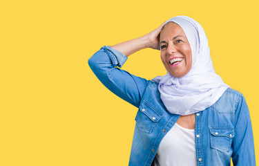 Middle age eastern arab woman wearing arabian hijab over isolated background Smiling confident touching hair with hand up gesture, posing attractive