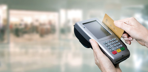 hand paying with credit card and store background