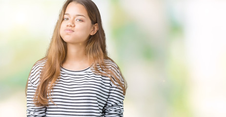 Young beautiful brunette woman wearing stripes sweater over isolated background puffing cheeks with funny face. Mouth inflated with air, crazy expression.