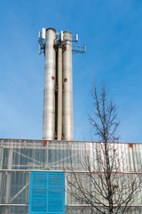 View on an industrial chimney with antennas on it.