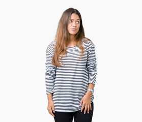 Obraz premium Young beautiful brunette woman wearing stripes sweater over isolated background making fish face with lips, crazy and comical gesture. Funny expression.