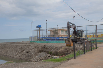 Fototapeta na wymiar Equipment, excavator on duty at sea beach shore to renovate and relocation prepare for development