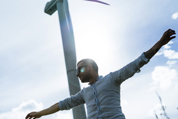 Man on a windmill background, summer windmills, sunset. Wind turbine, wind power. wind power plant