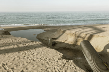 Industrial wastewater, the pipeline discharges liquid industrial waste into the sea on a city...