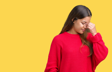 Young beautiful brunette woman wearing red winter sweater over isolated background tired rubbing nose and eyes feeling fatigue and headache. Stress and frustration concept.