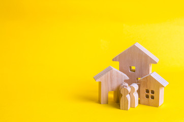 Fototapeta na wymiar Wooden houses and people on a yellow background. The concept of buying home sales, rent. Construction and relocation. Adaptation in the new city. Investments and insurance. City authorities.