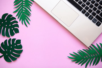 Workspace in a pink trendy color or summer design with a concept to start a vacation. Laptop and...