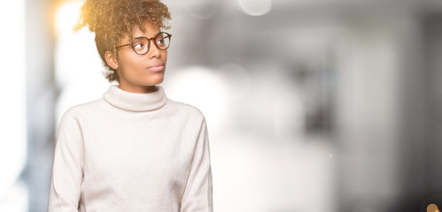 Beautiful young african american woman wearing glasses over isolated background smiling looking side and staring away thinking.