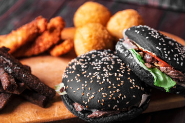 Black hamburger, fast food on wooden background