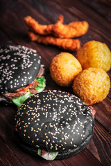 Black hamburger, fast food on wooden background, vertical frame
